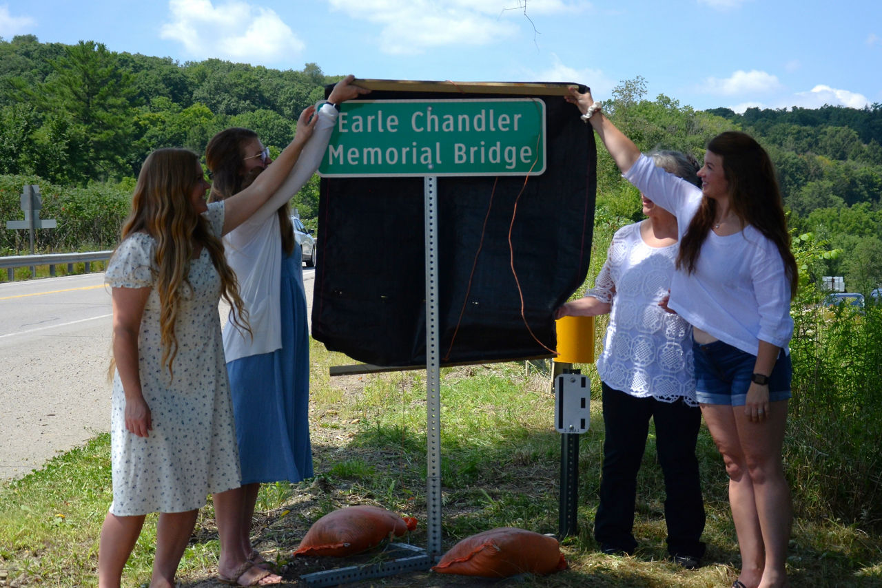 The Chandler family unveils the Earle Chandler Memorial Bridge sign. 