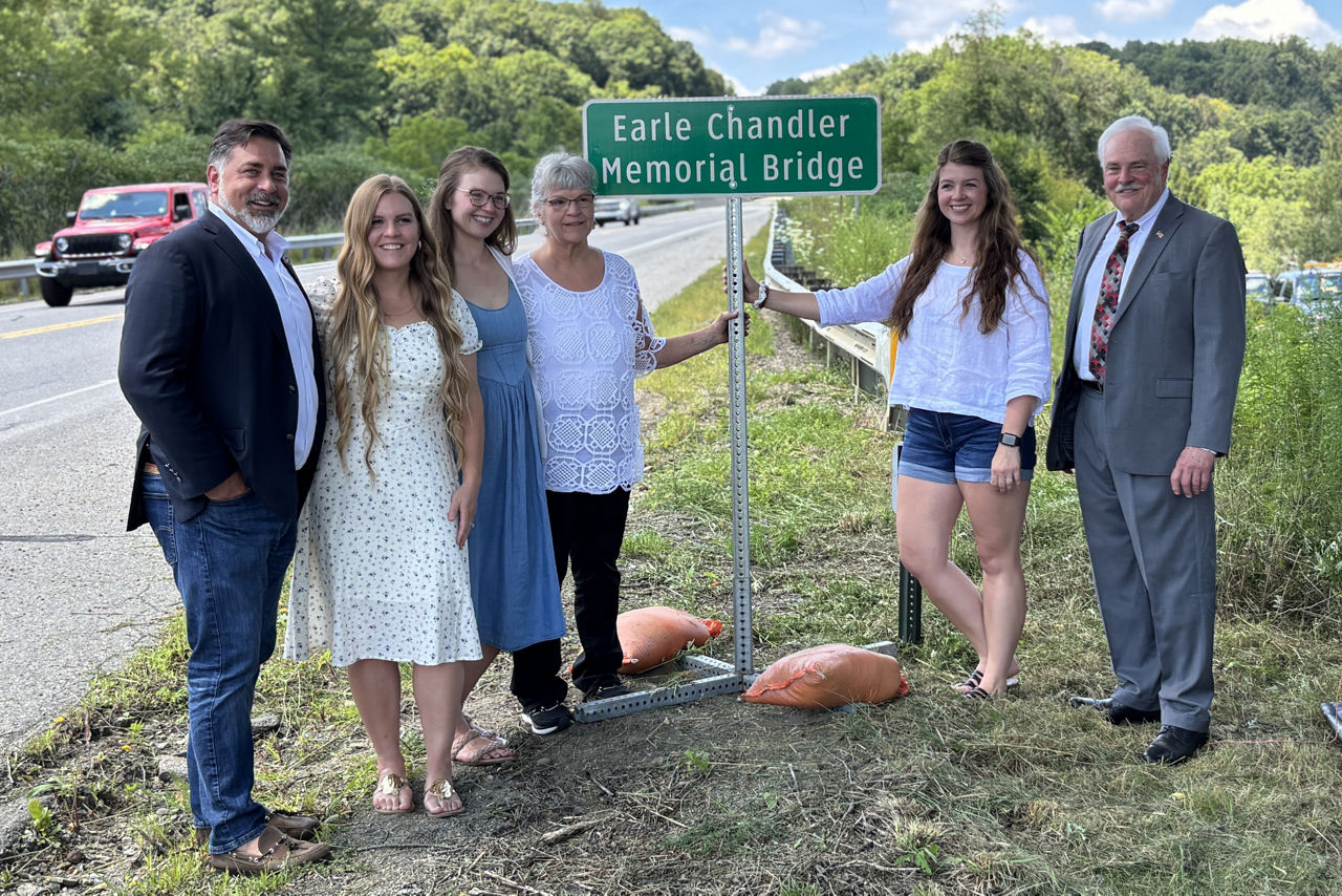 The family poses with the sign. 