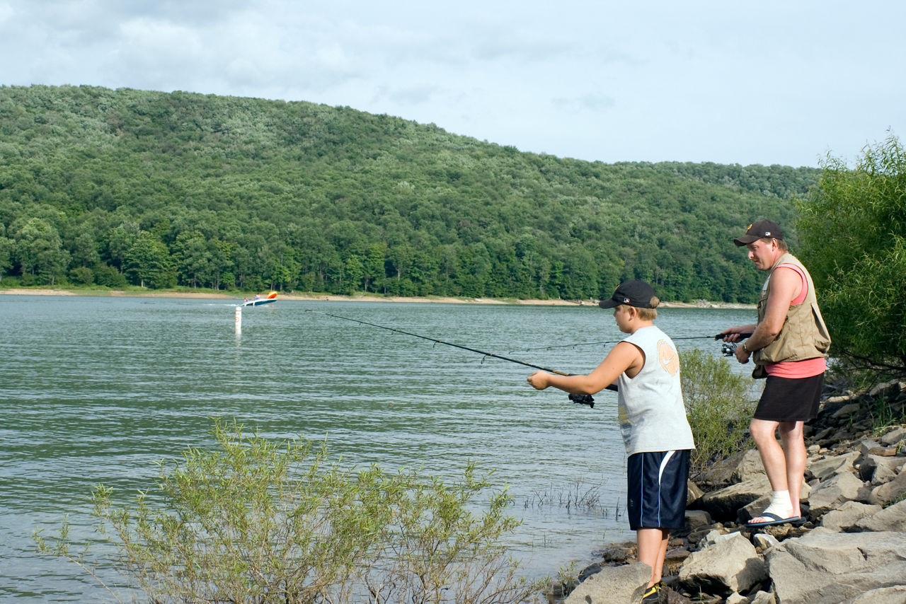 Two men fishing from the rocky lake shore