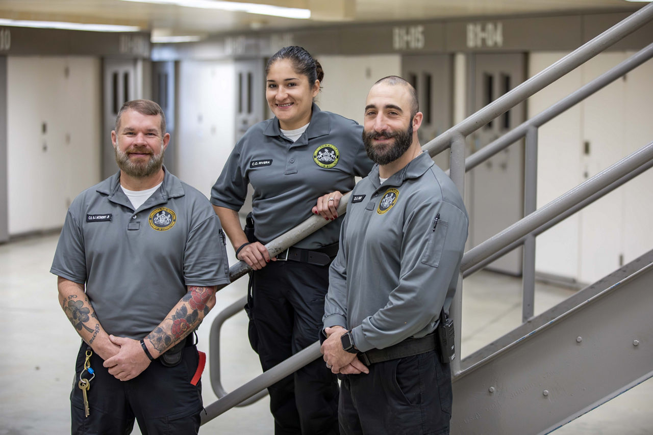 Three corrections officers standing in a housing unit