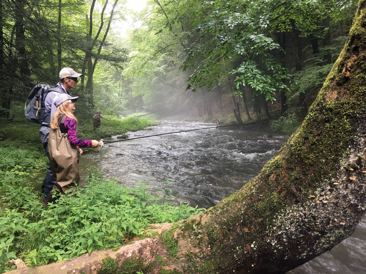 Father and daughter fishing on stream 
