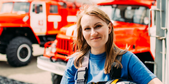 Image of a Firefighter with firetrucks in the background