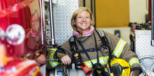 Firefighter leaning on fire truck 