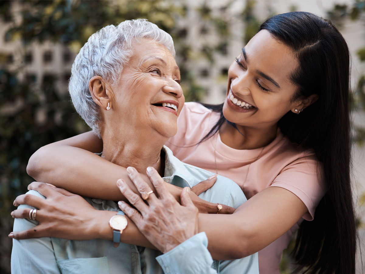 Younger woman with arms around older woman