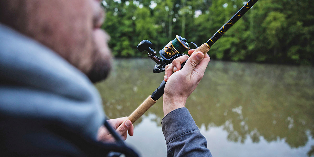 Close-up of a man casting his fishing rod out on a lake