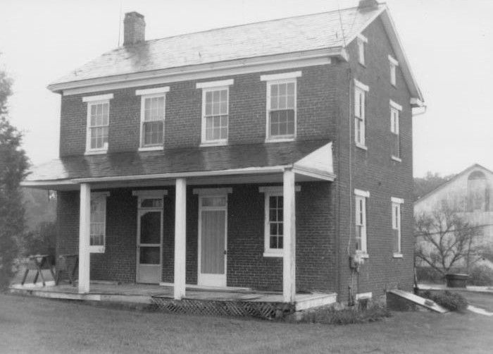 Two –story, four-bay with two central front doors brick farmhouse with    a full front porch and a side- gabled roof with interior side wall chimneys.