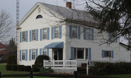 Two story front facing gable home with door on the right side and four bays in width.