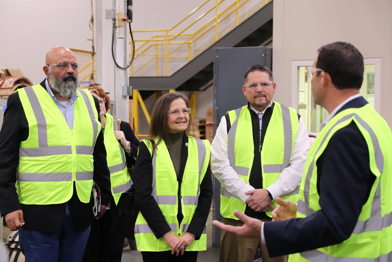 L&I Secretary Nancy A. Walker and Deputy Secretary Gerald Mullery stand in safety goggles and vests with BCI Lancaster staff.
