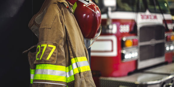 Firefighter gear hanging near a firetruck.