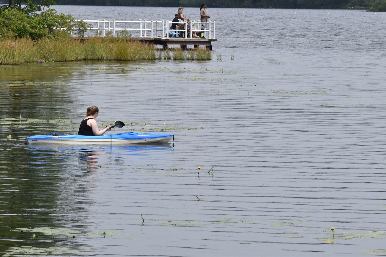 A kayaker and two fishermen enjoying the lake