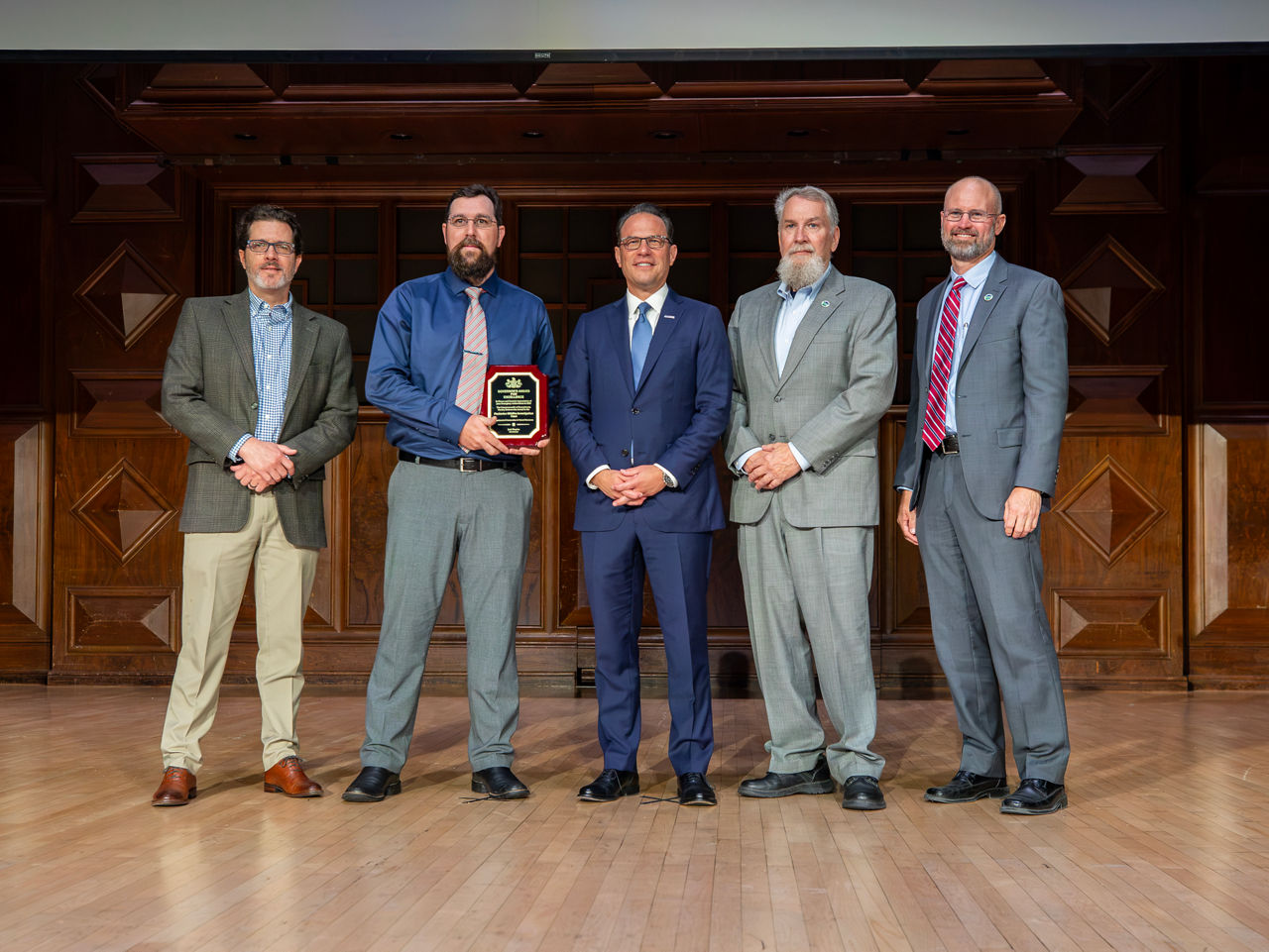 poses for a photo with Governor Josh Shapiro while receiving a Governor's Award for Excellence.