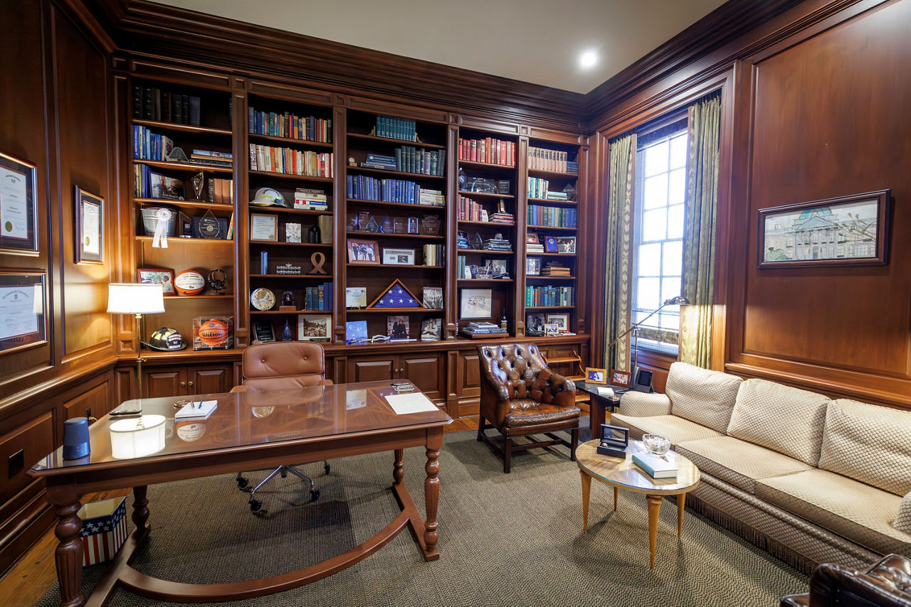 Elegant wood-paneled office with bookshelves and seating area