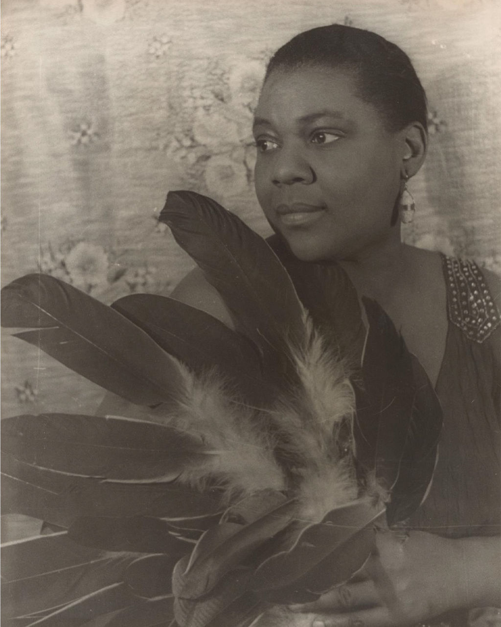 Vintage portrait with large feathers and floral backdrop