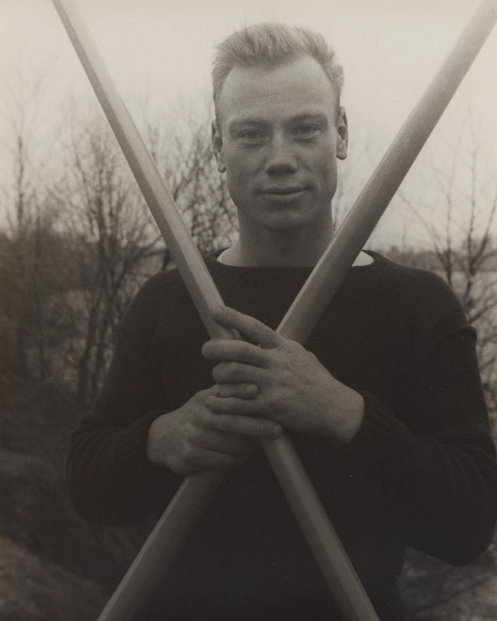 Person holding crossed poles outdoors in grayscale photo