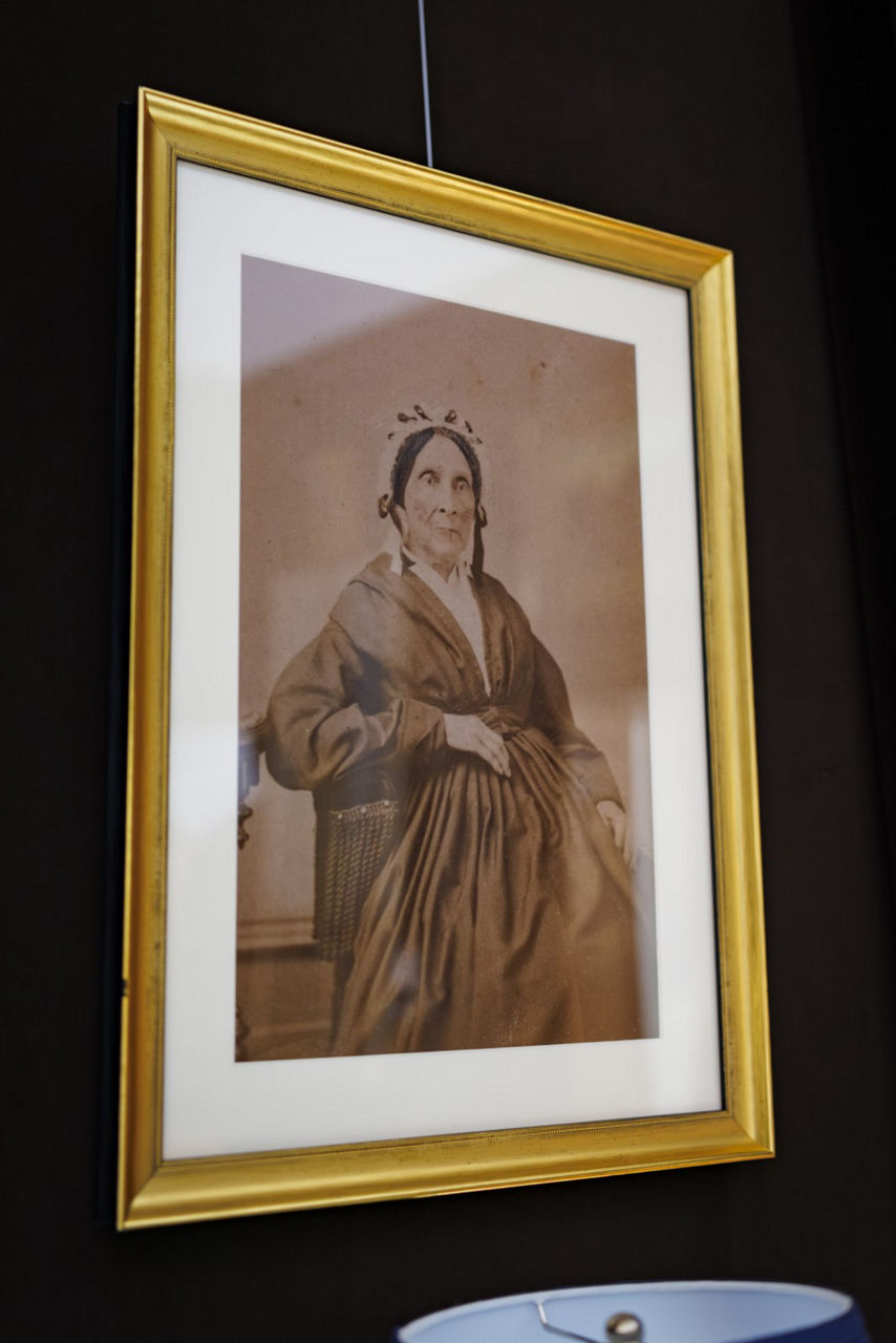 Framed vintage portrait of seated woman on wall