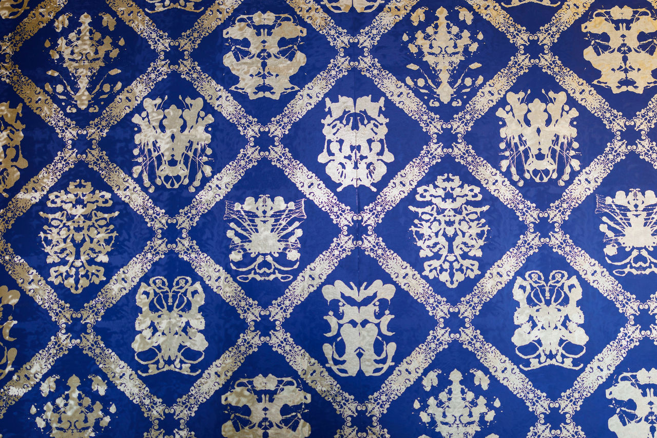 Blue and cream ornate symmetrical wallpaper pattern