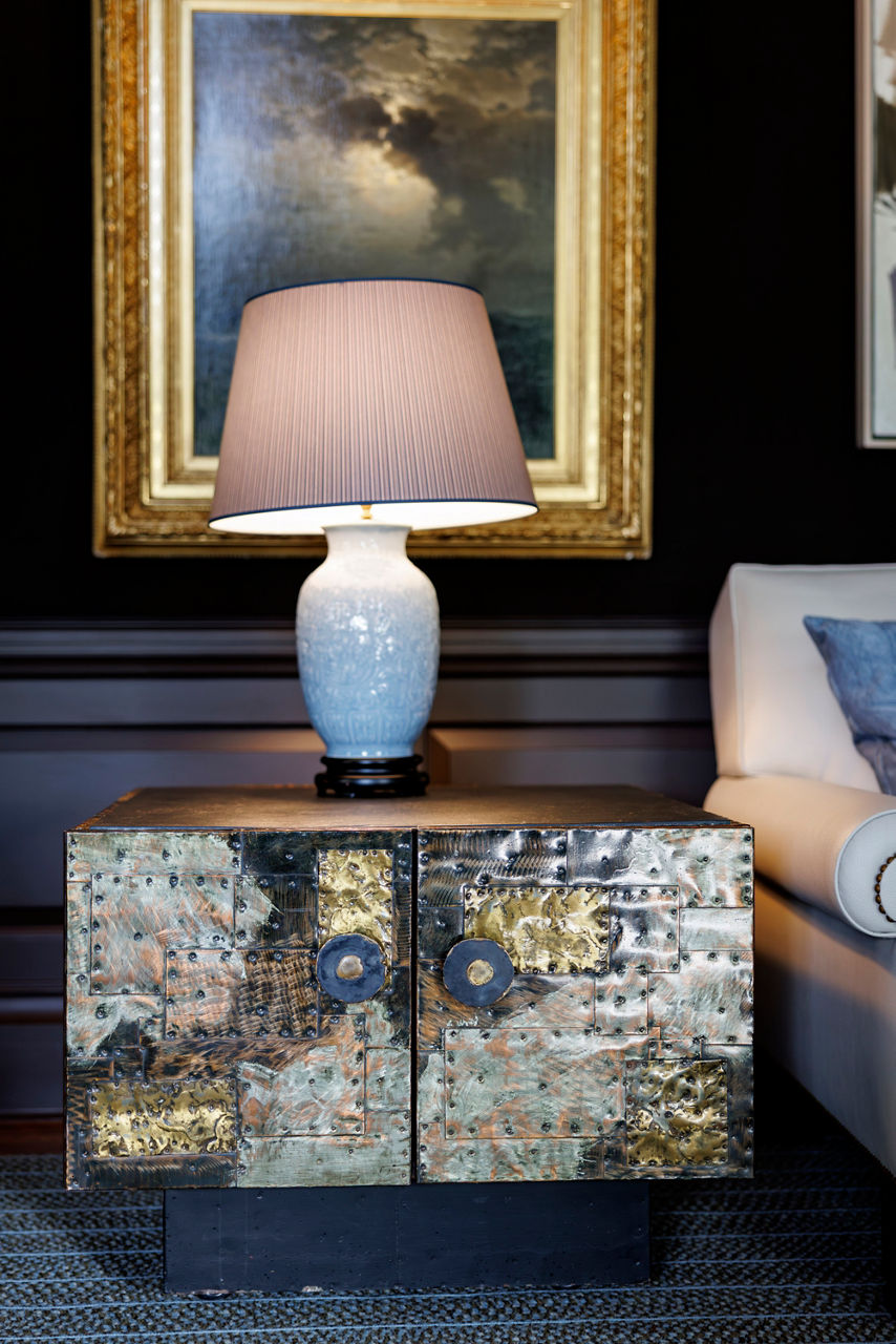 Metallic side table with ceramic lamp in living room.