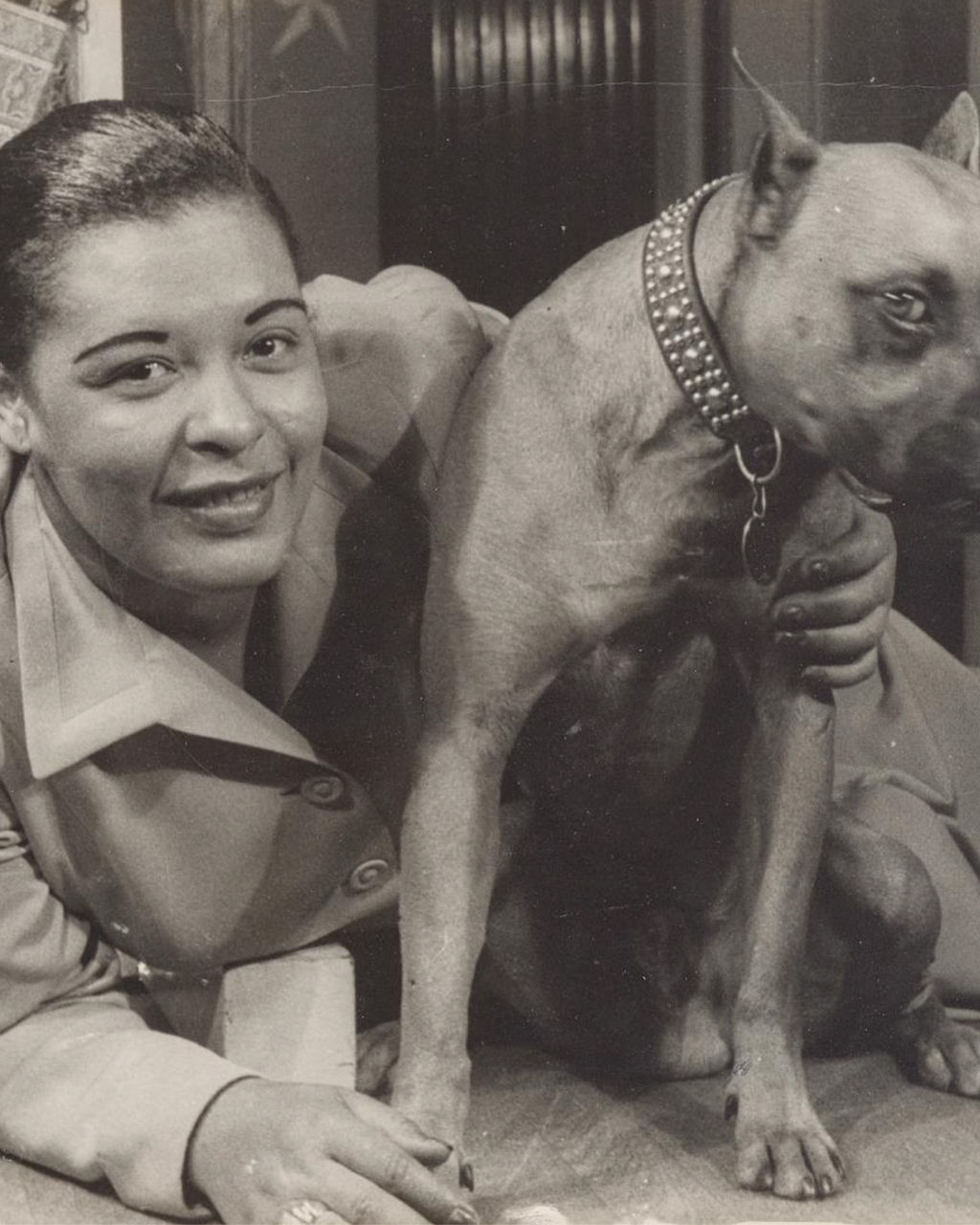 Person with large dog wearing studded collar indoors