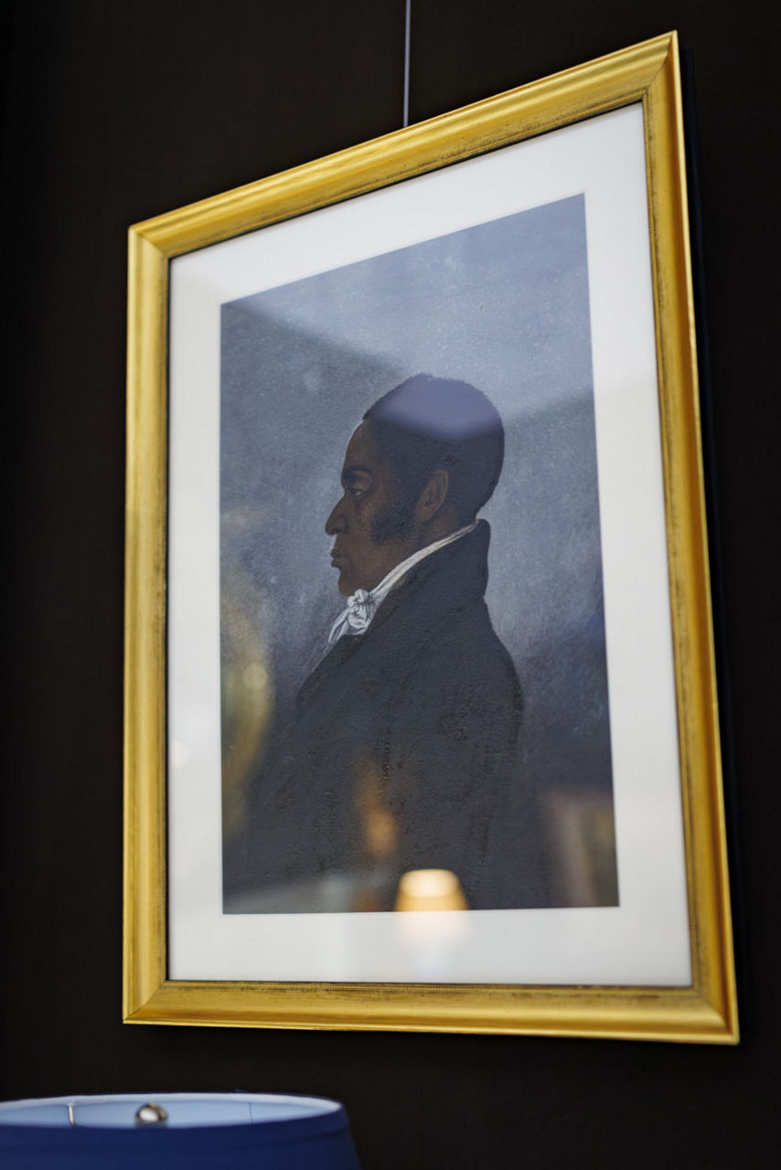 Framed portrait artwork with gold border on wall