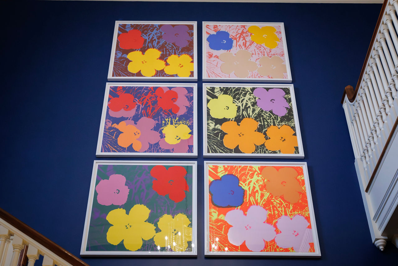 Six abstract art being hung in the stairwell 