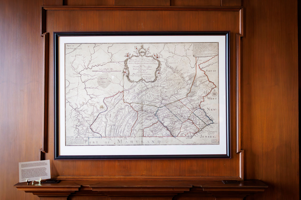 Framed antique map displayed on wooden wall