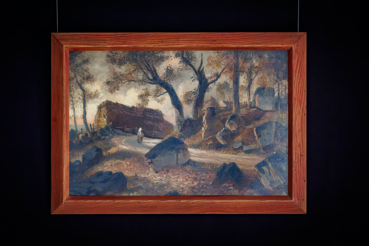 Framed landscape painting with rural cottage scene.