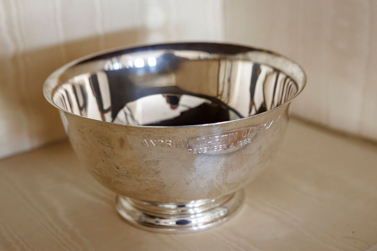 A shiny silver bowl engraved with text.