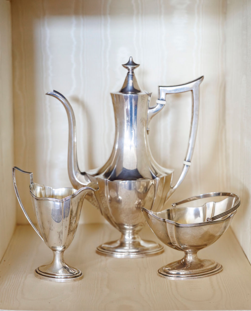 A silver set that includes a tall coffee pot, creamer pitcher, and sugar bowl.