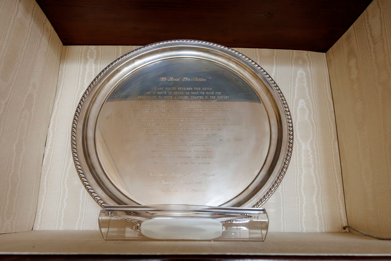 A polished silver platter with engraved text.
