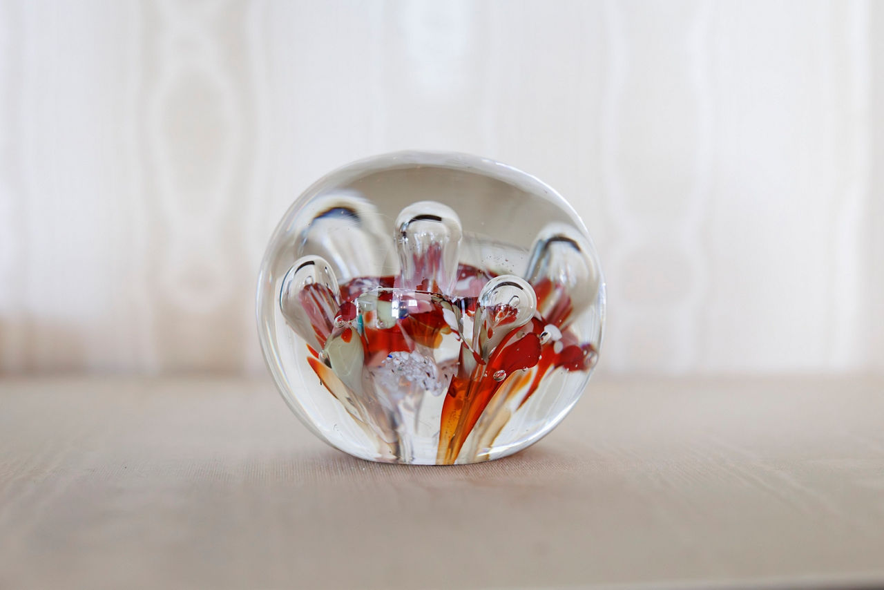 A glass paperweight with swirling red, orange, and white colors, resembling flames.