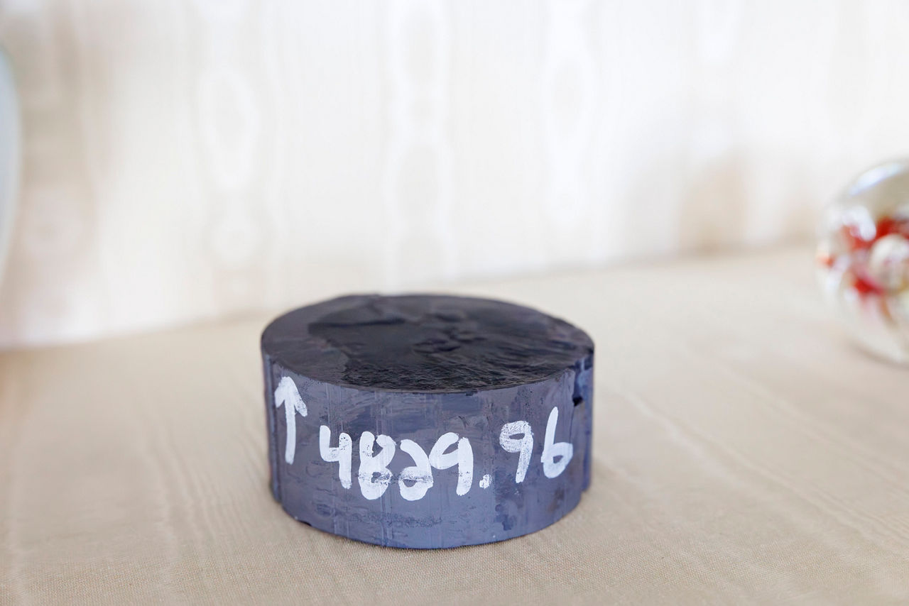 Marcellus shale core sample with an up arrow and number in white paint.