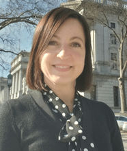 Gwen Ross smiling, with a building behind her
