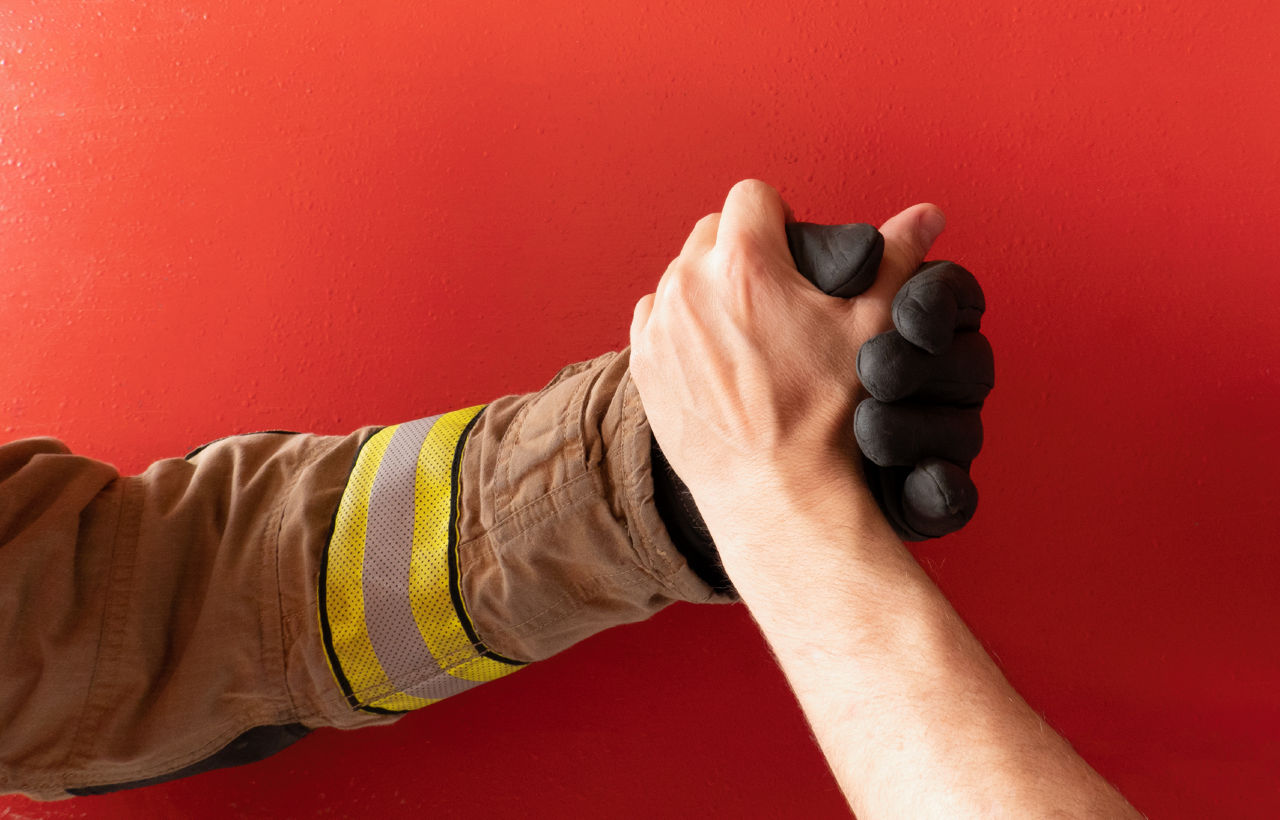A firefighter shakes hands with a person not in uniform.