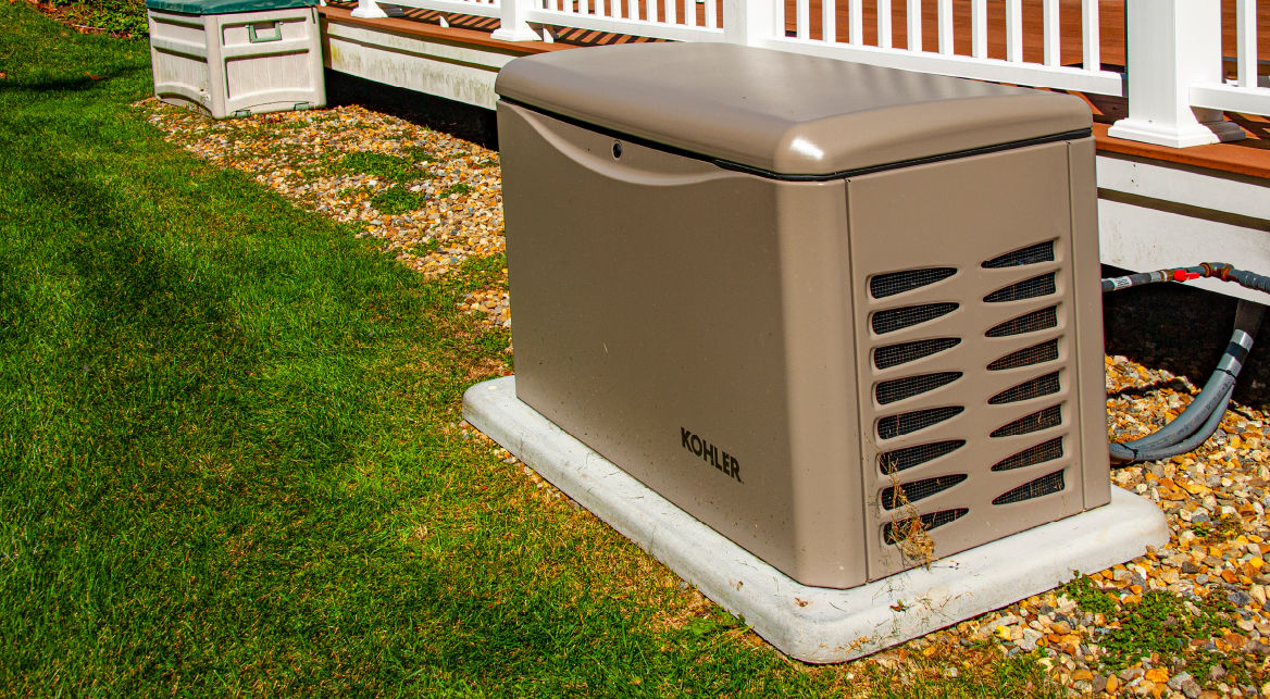 A home generator sits outside on a concrete slab.