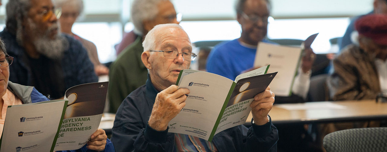 An older adult reads the Pennsylvania Emergency Preparedness Guide.