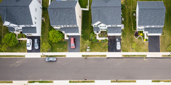 Aerial view of four houses in the same neighborhood.