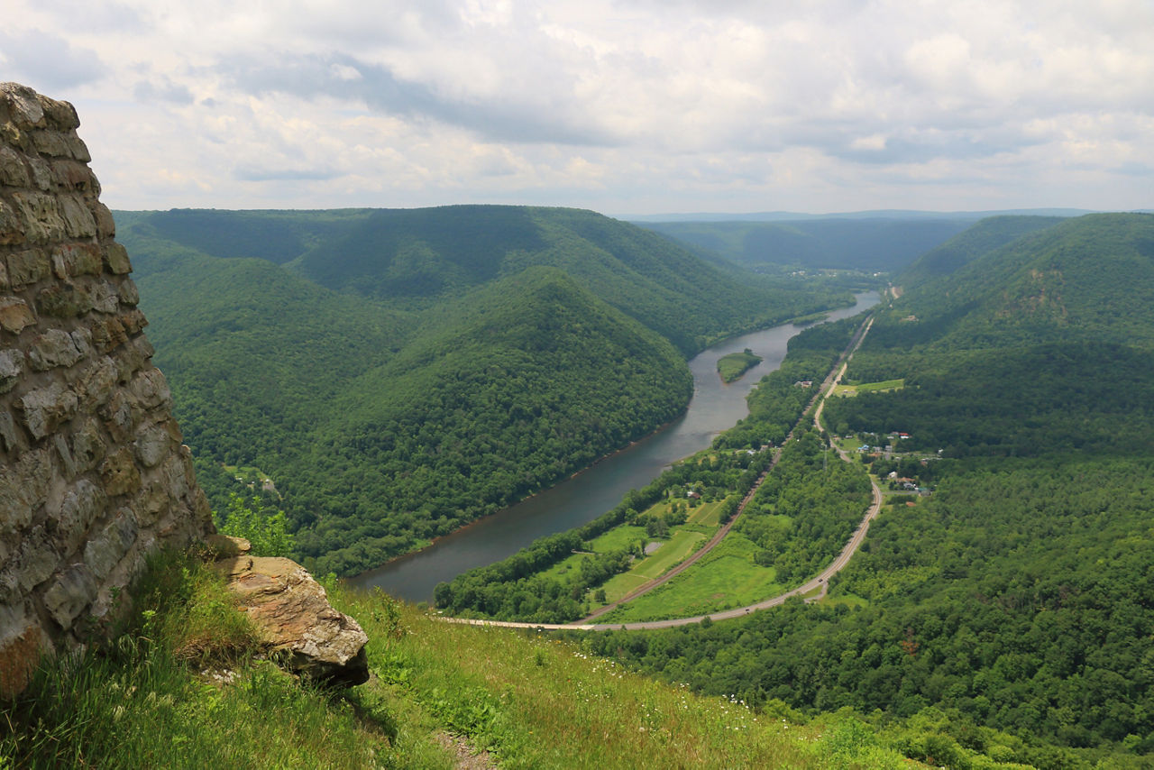 A stoney structure overlooking a lush green river and valley