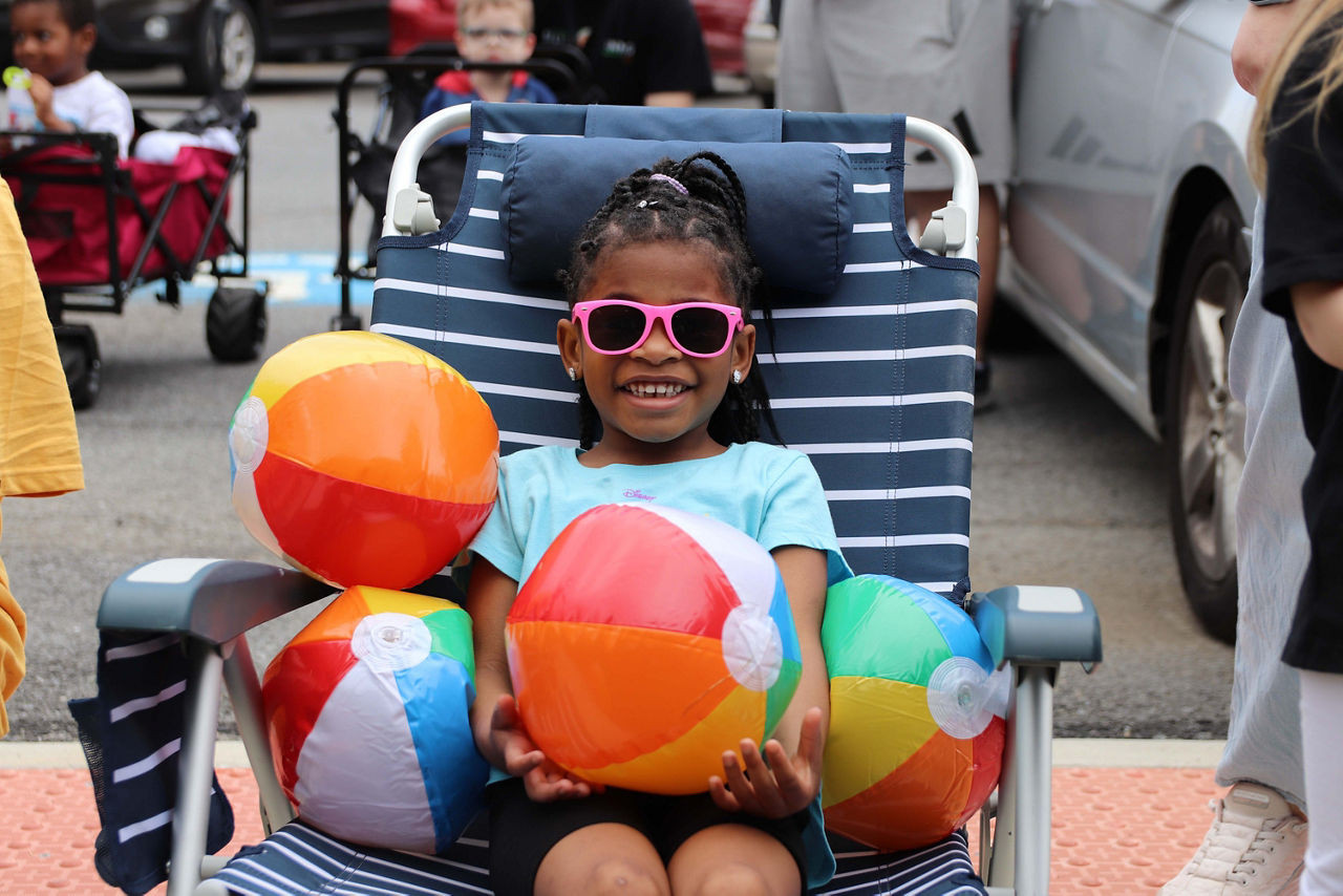 girl with sunglasses sits on beach chair at 2026 Autism Walk at CTI at HGAC 