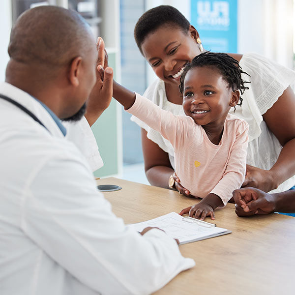 A child high-fiving a doctor.