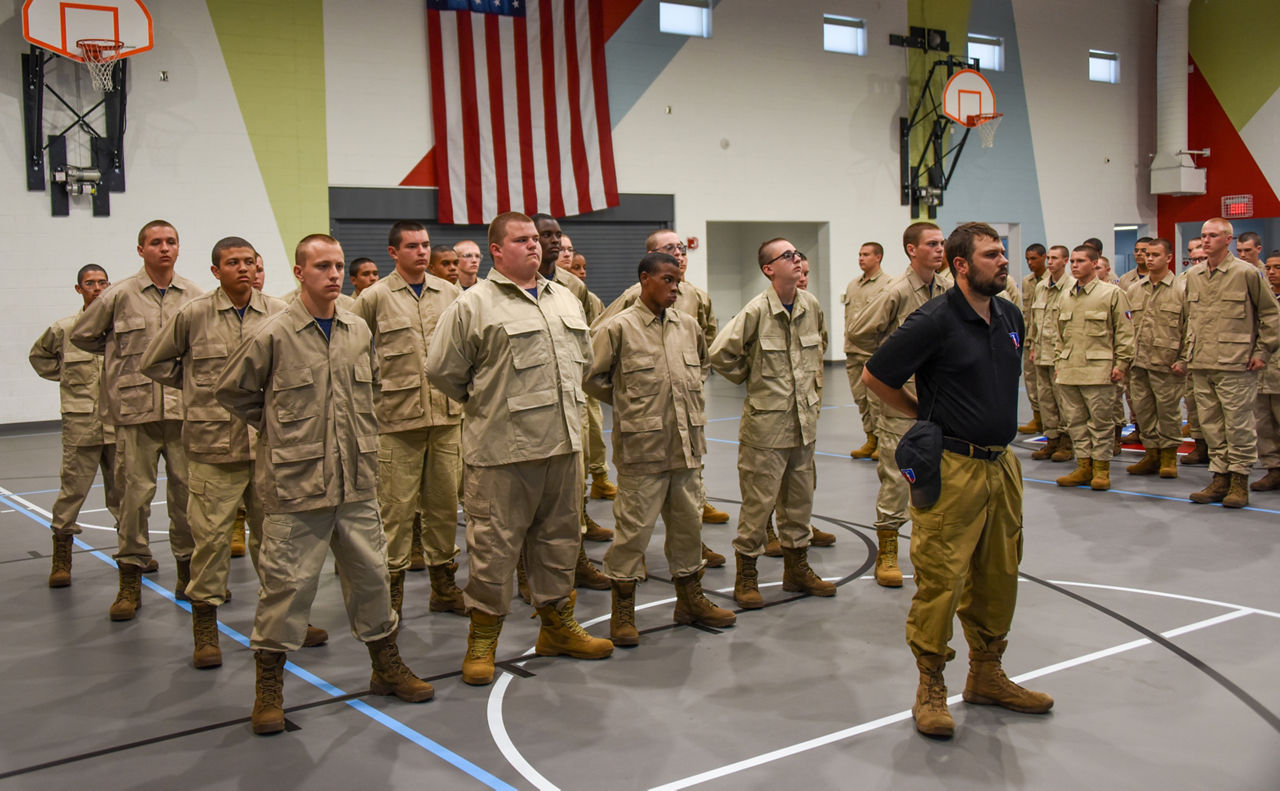 A group of cadets standing in formation in a gymnasium. 