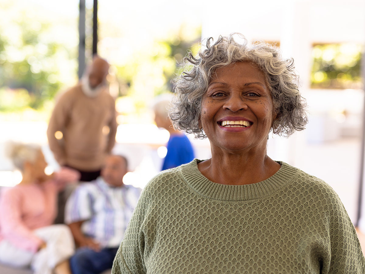 Portrait of smiling african american senior woman standing with multiracial friends in background