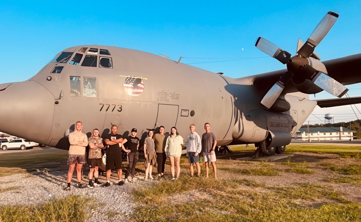 Law and Leadership Academy cadets pose in front of a military aircraft 
