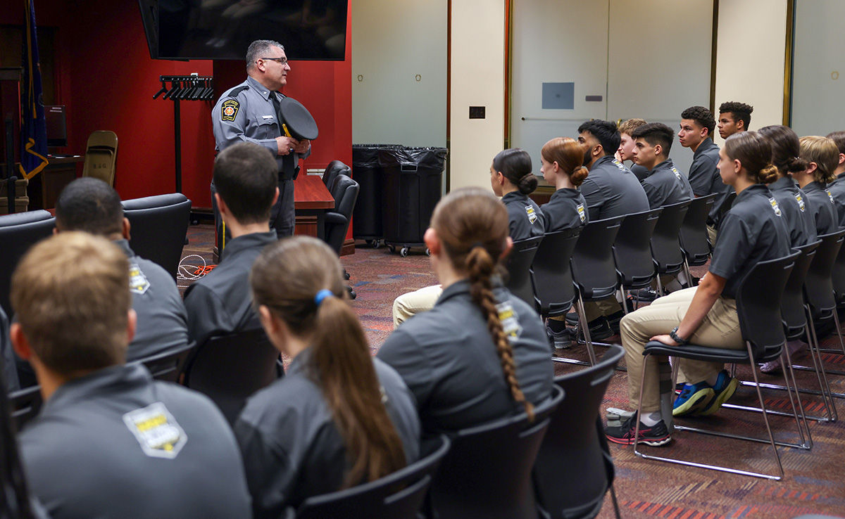 Colonel Paris talks to a group of Law and Leadership Academy cadets indoors; the cadets are seated