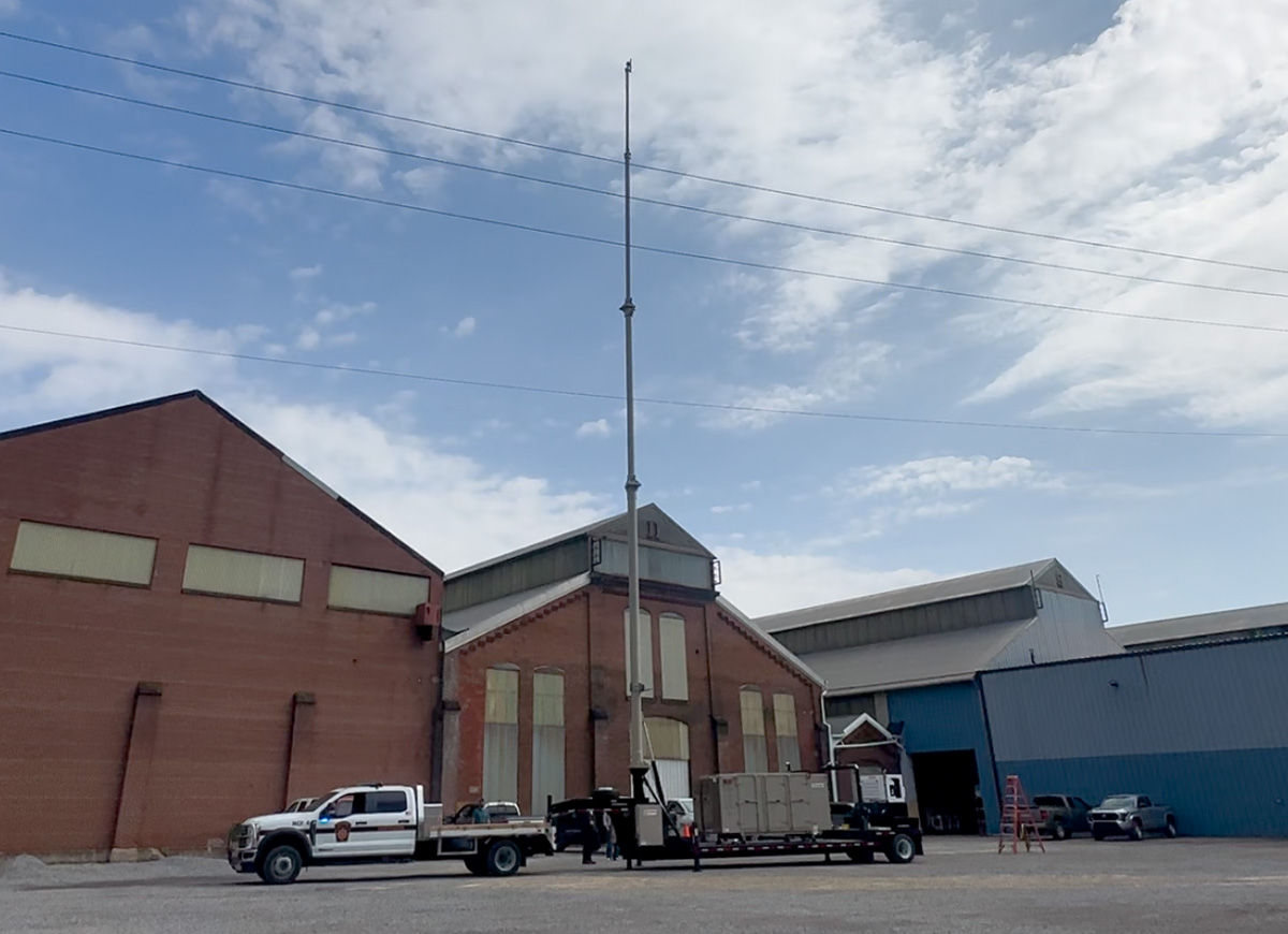 A Pennsylvania State Police truck tows a Land Mobile Radio Cell On Wheels trailer and the 100 foot tower is extended