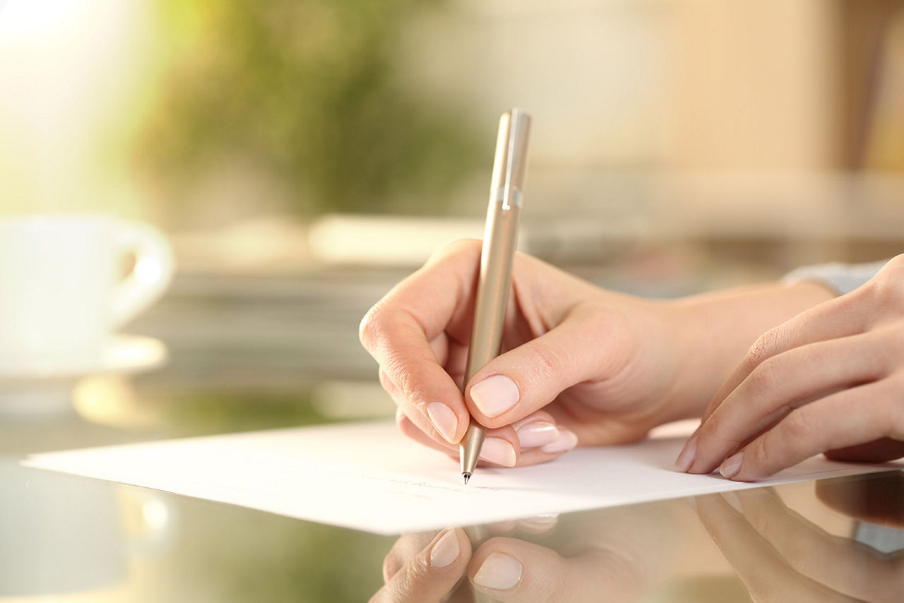 A person writing a letter