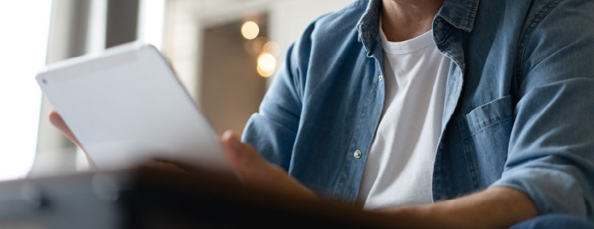 A man uses a tablet at home.