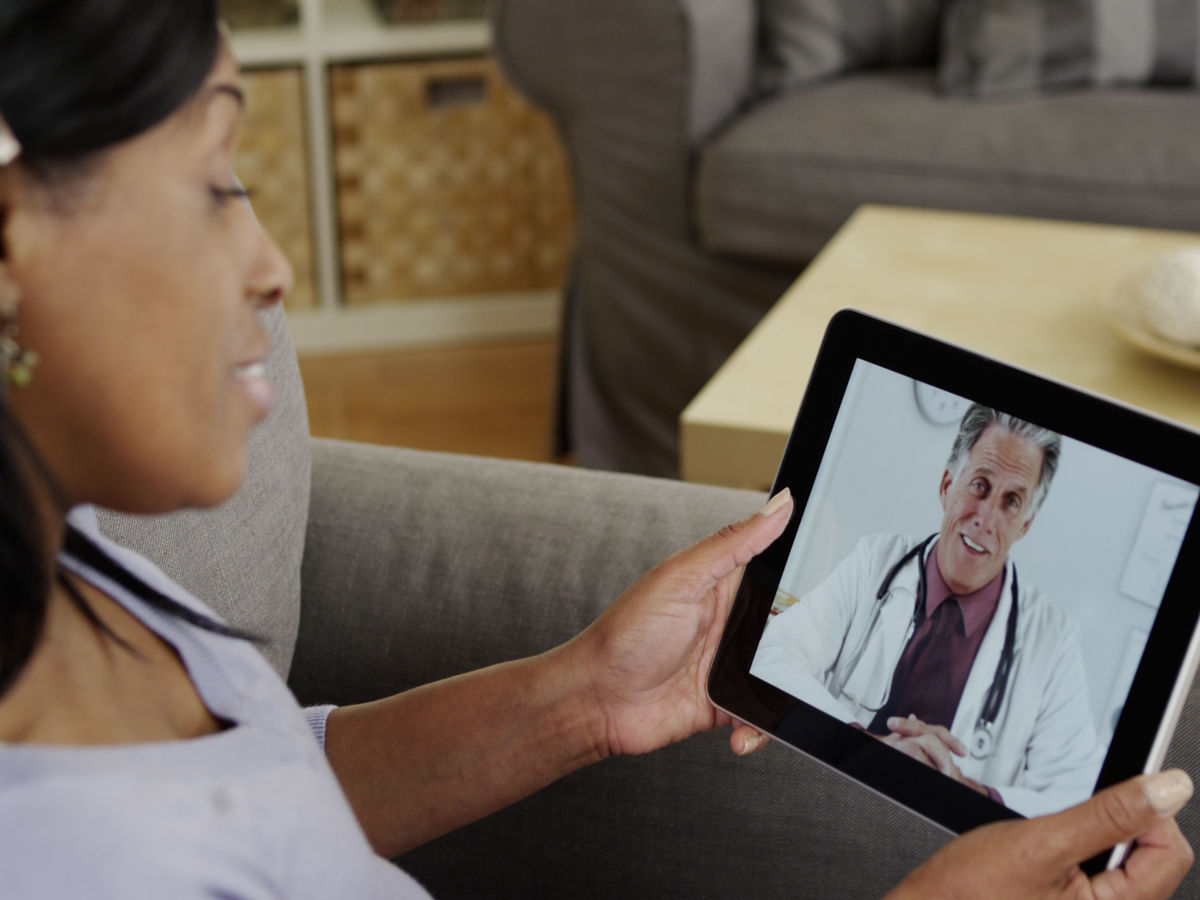 woman talking with a doctor using a tablet