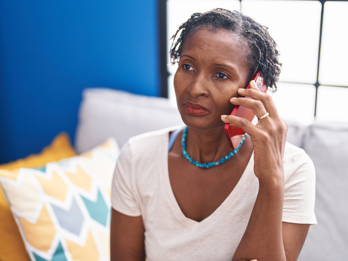 woman holding phone looking concerned