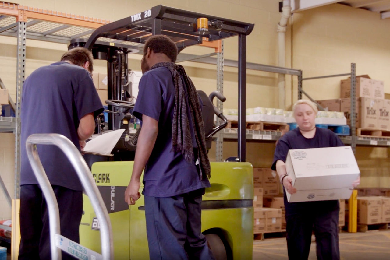 Materials Management students place boxes on a forklift