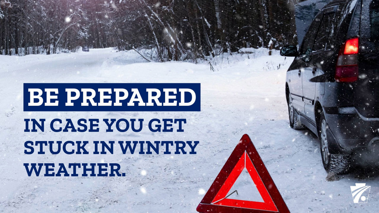 Photo of a car in winter weather with orange emergency triangle